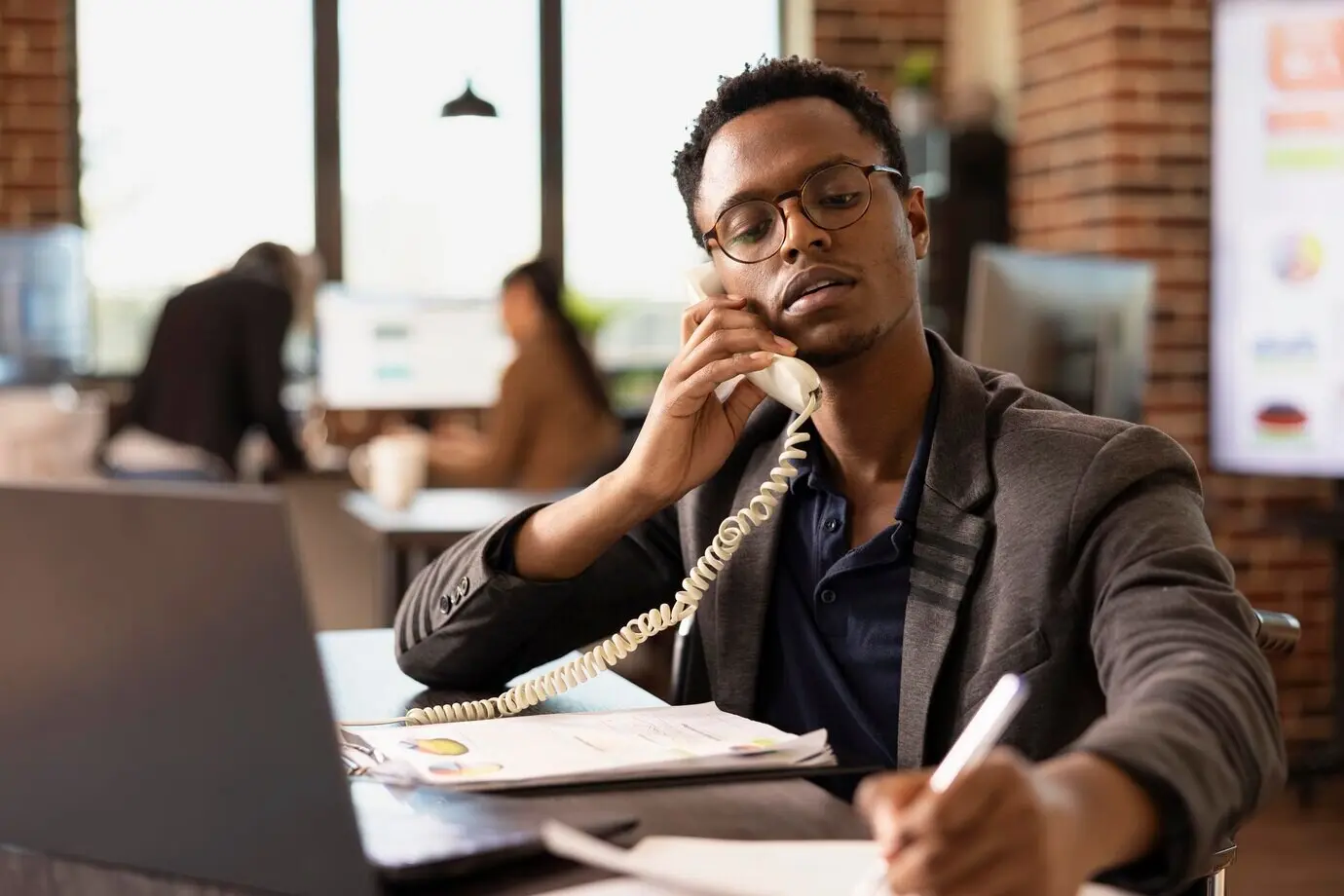 Менеджер делает заметки во время телефонного разговора.